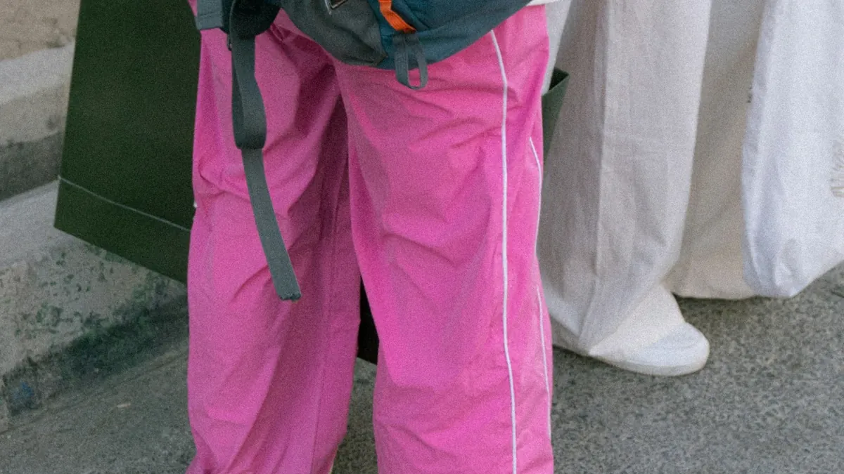Person in bright pink pants with backpack and backpack
