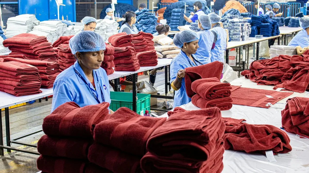 Workers fold and stack textiles in a factory