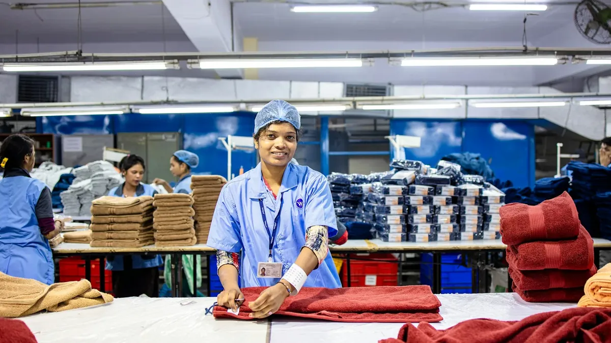 Workers fold towels in a factory setting