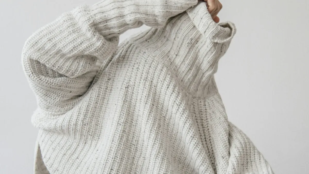 Person wearing grey knit sweater