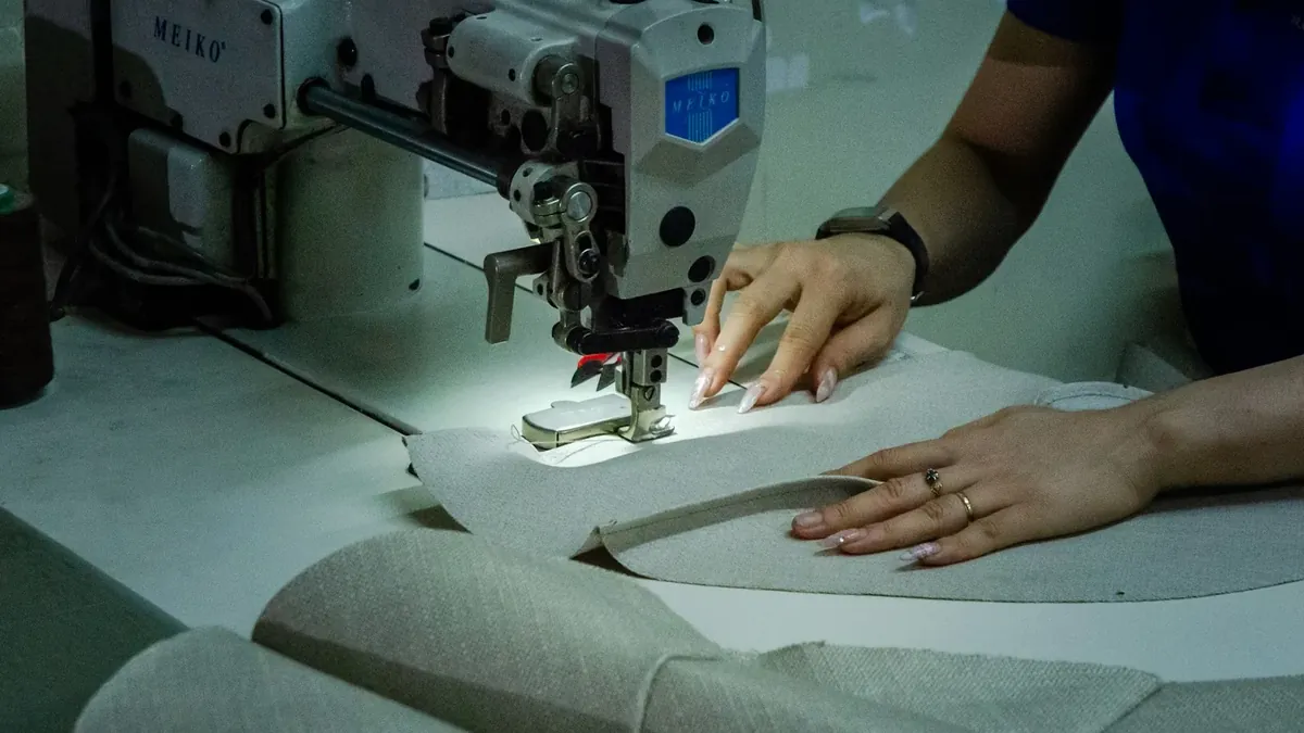 A woman using a sewing machine to sew fabric