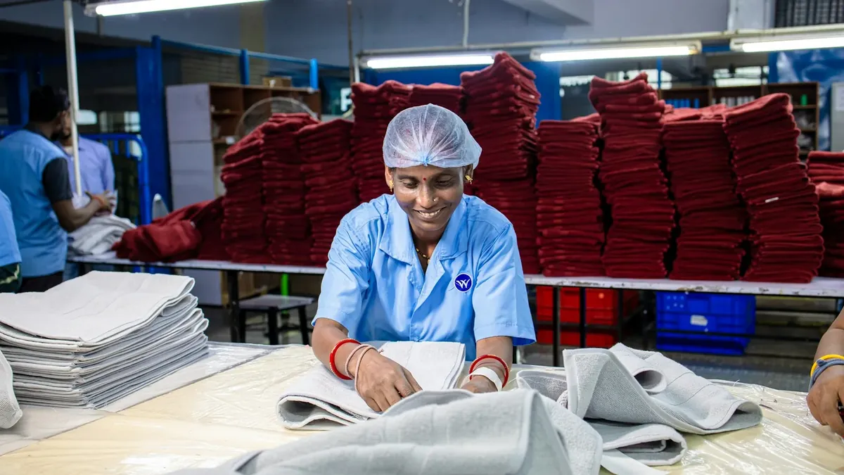 Woman folds towels in a factory setting