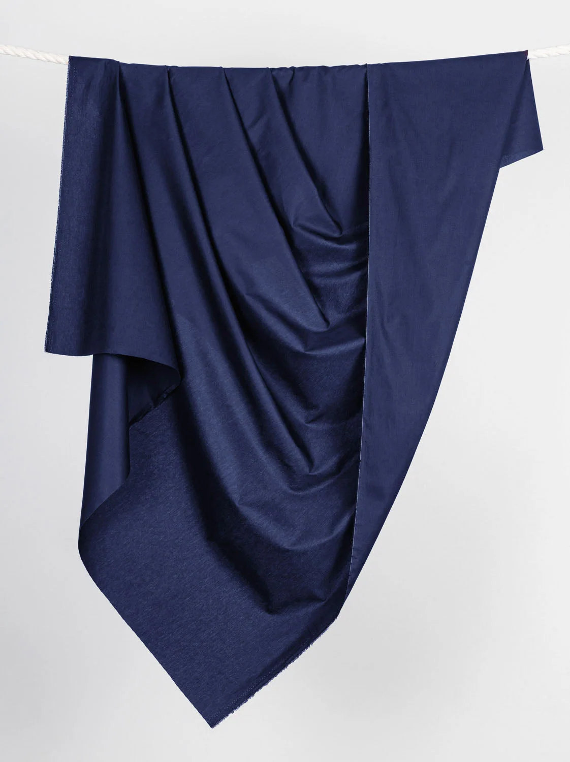 A length of navy woven fabric hanging to show its drape.