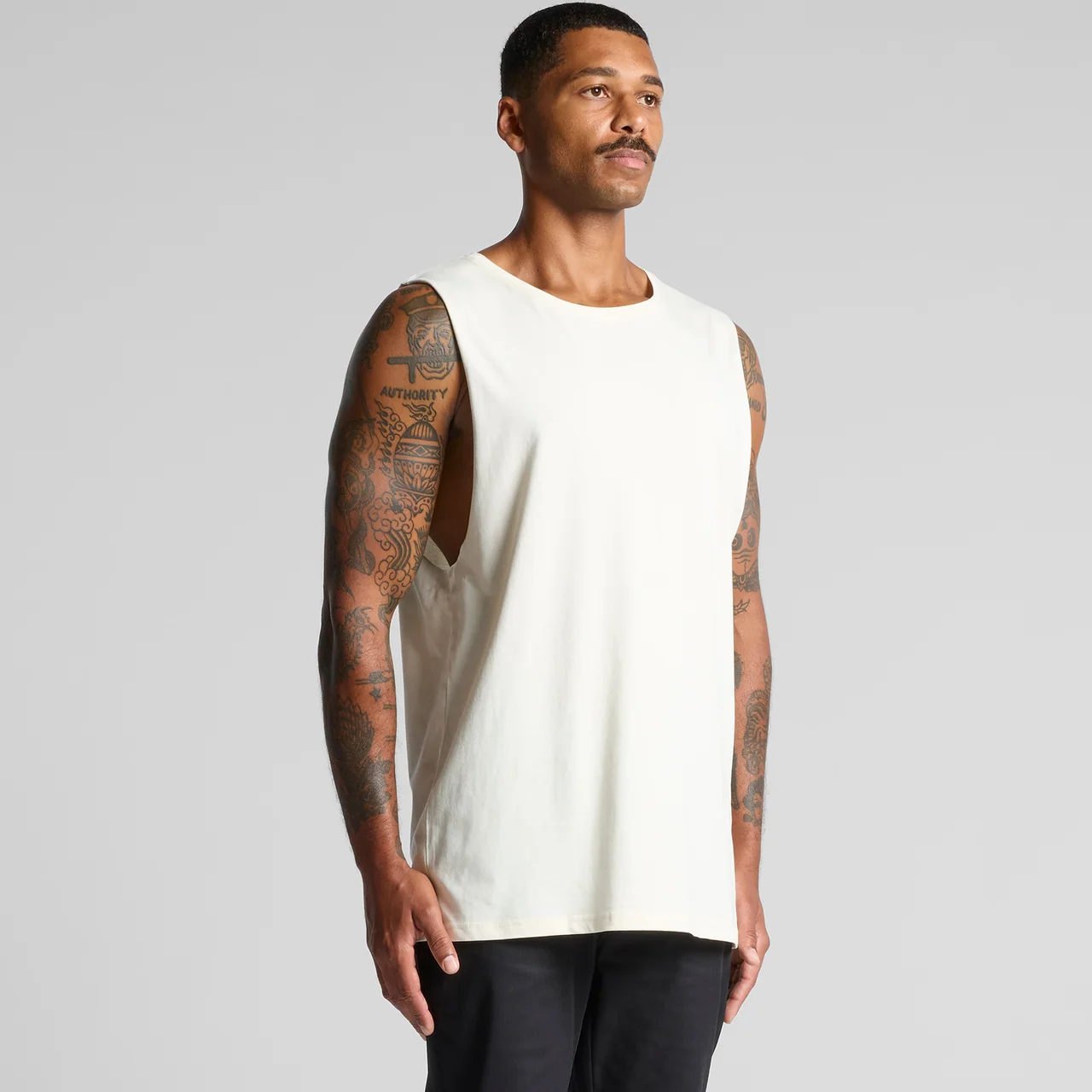 An off-white sleeveless tank worn at an angle to show its neckline and shoulder shape.