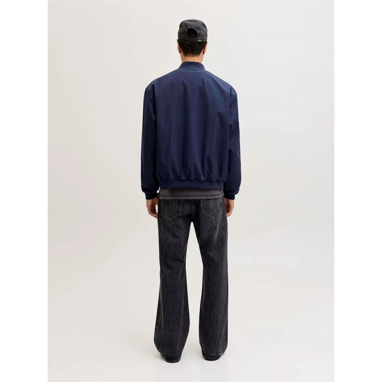 Back view of a navy bomber jacket with ribbed waistband and cuffs.