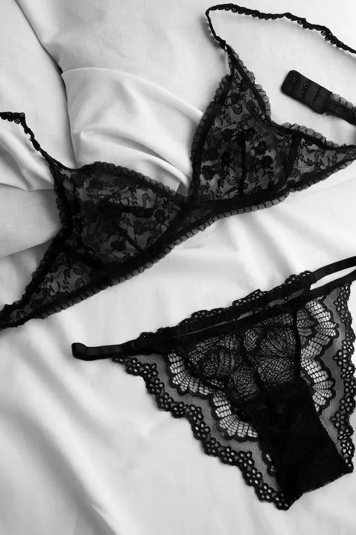 Lingerie en dentelle noire montrant les bords festonnés et une fermeture à agrafes.