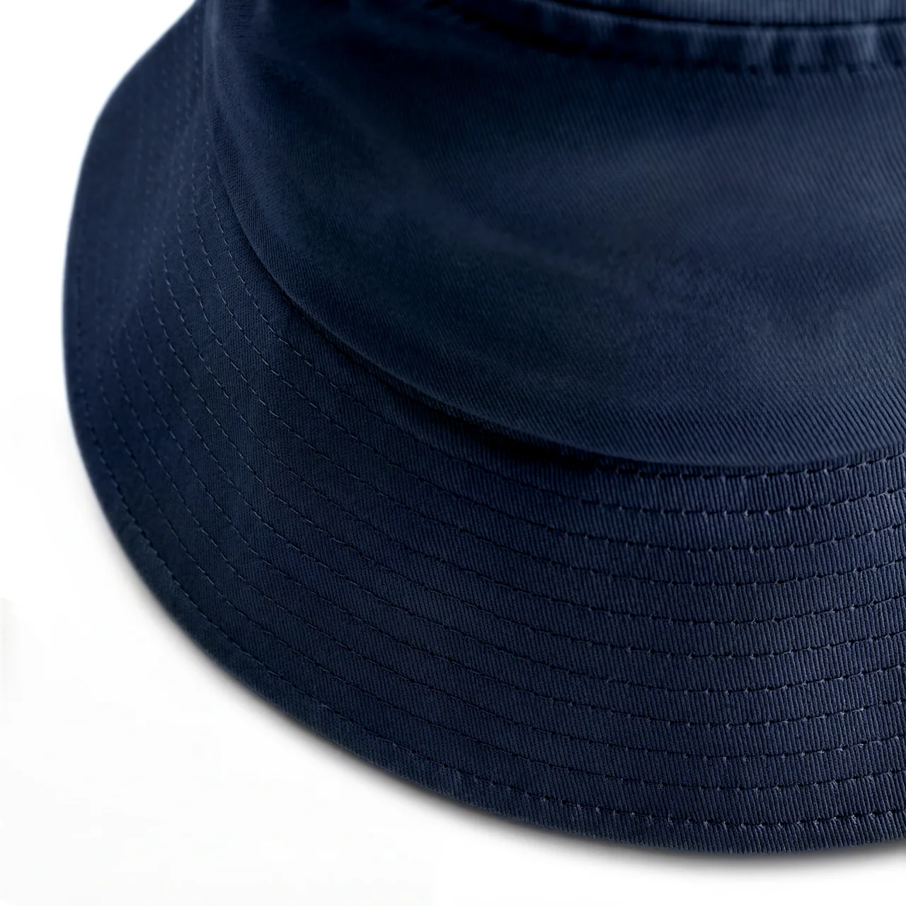 Close view of a navy bucket hat showing parallel brim stitching and the seam joining the crown.