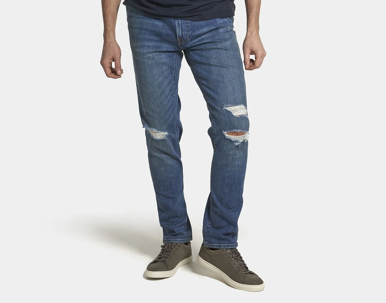 Distressed blue jeans showing the leg shape and washed finish.