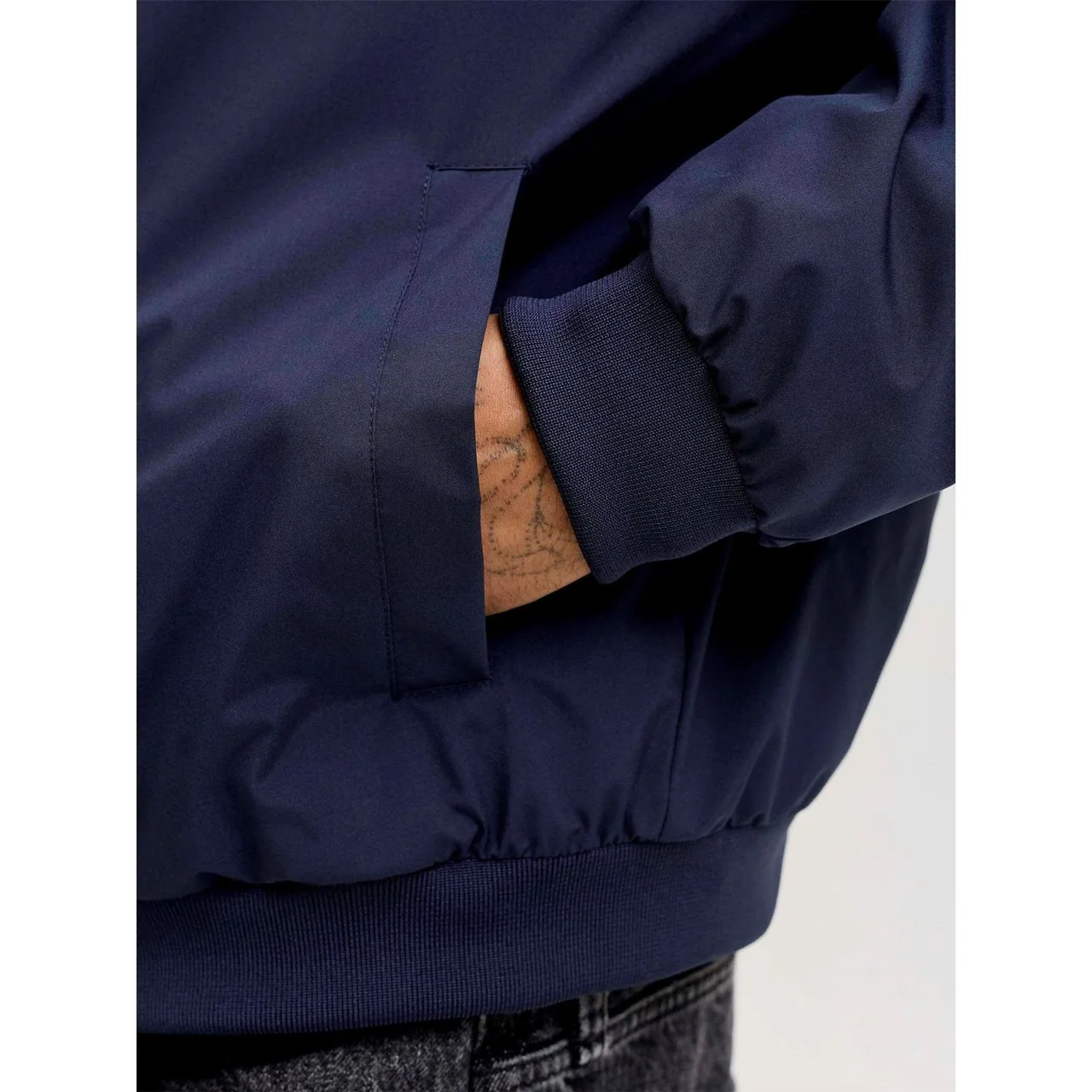 Navy jacket sleeve and waistband with ribbed finishing and a side pocket.