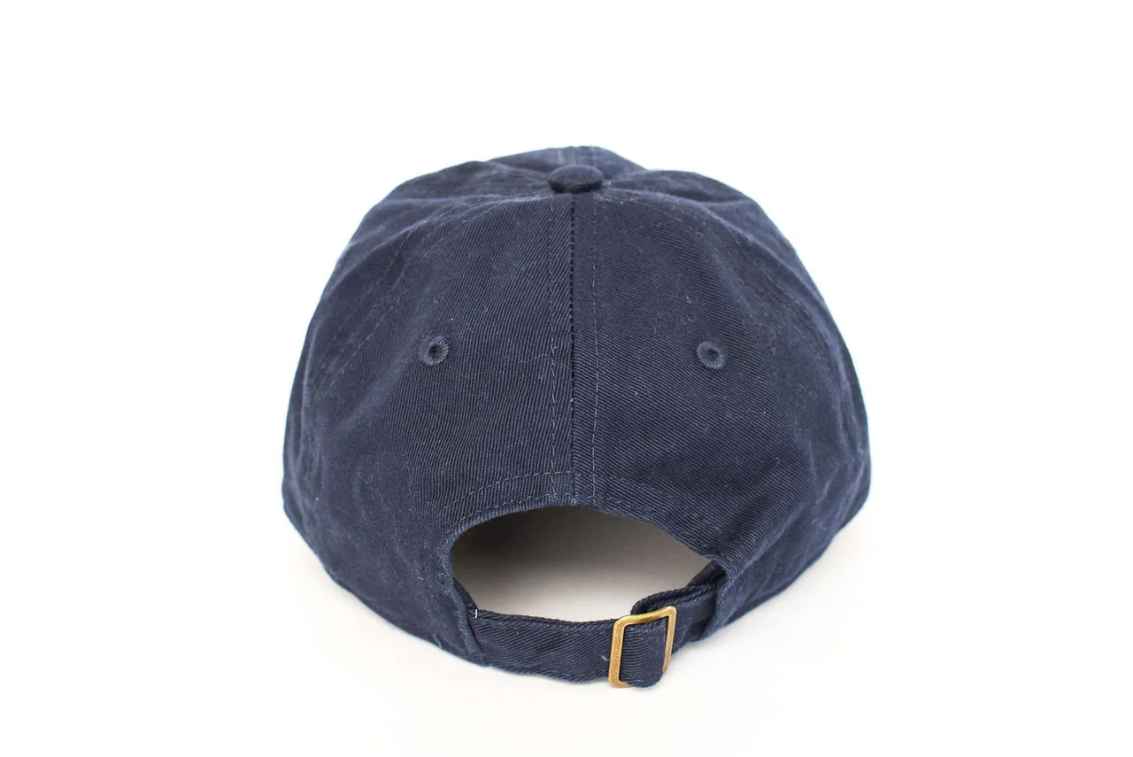 Rear view of a navy cap showing its adjustable strap and metal buckle.