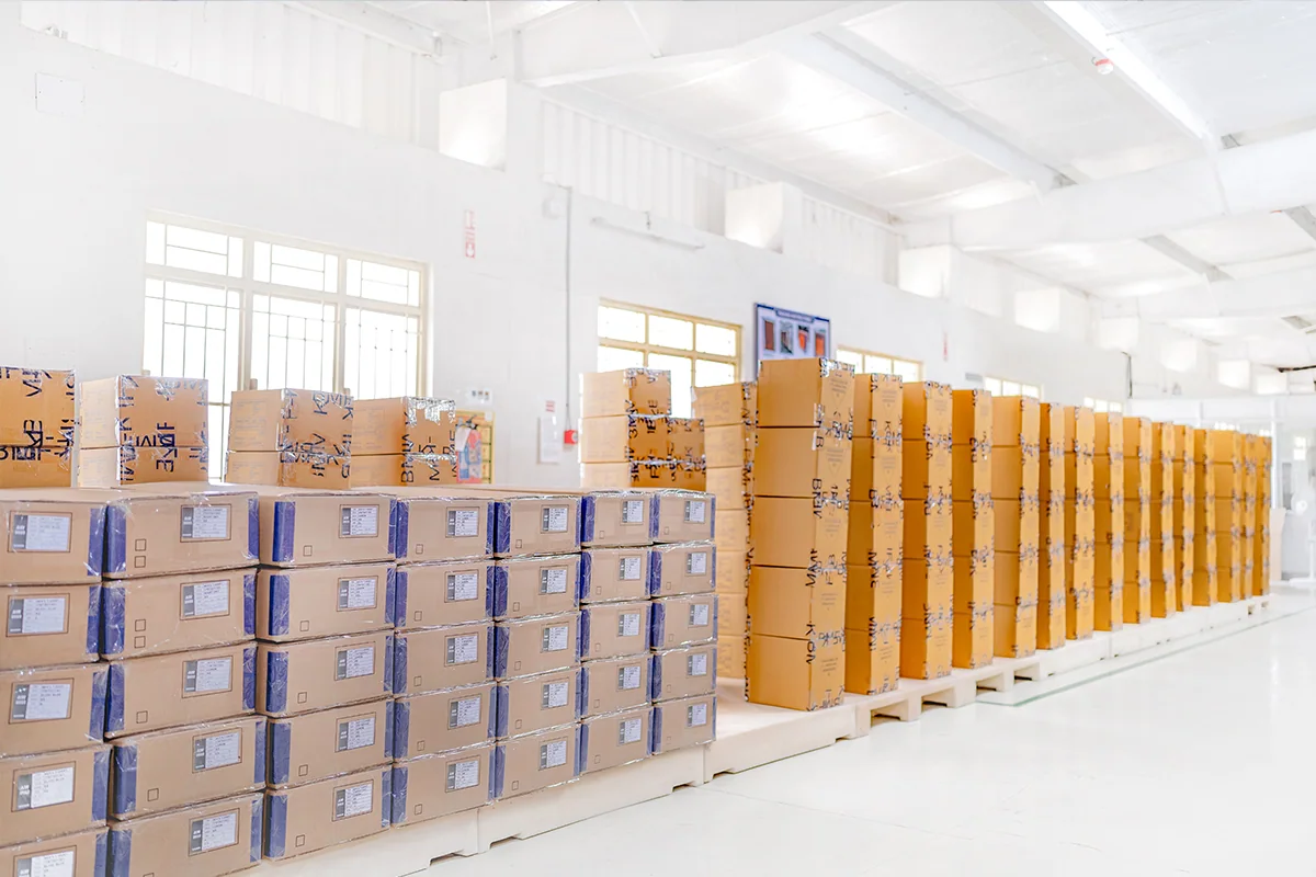 明るい出荷室に、封をした輸出用カートンが列をなして整然と並んでいる様子。