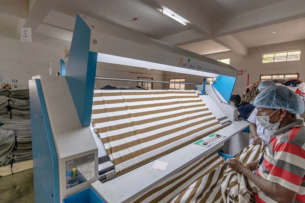 Striped fabric being examined on a lit fabric inspection machine.